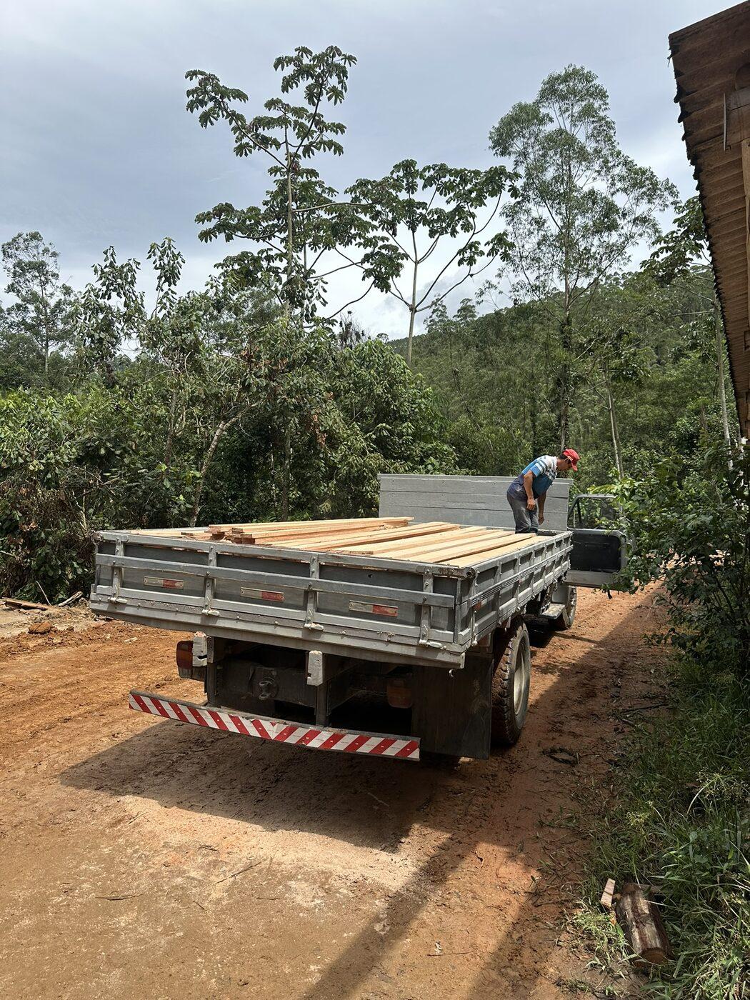 Caminhão carroceria com madeira em chácara